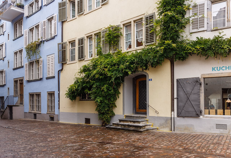 Kopfsteinpflastergasse in der Altstadt von Chur mit Efeu