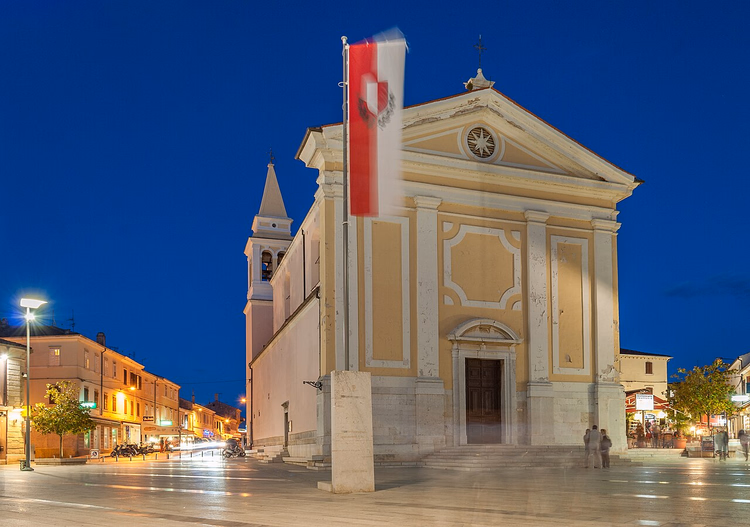 Trg slobode in Poreč in de avond met een kerk