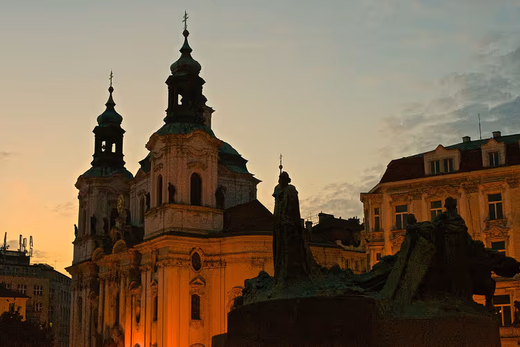 Sint-Nicolaaskerk en het Jan Hus-monument bij zonsondergang