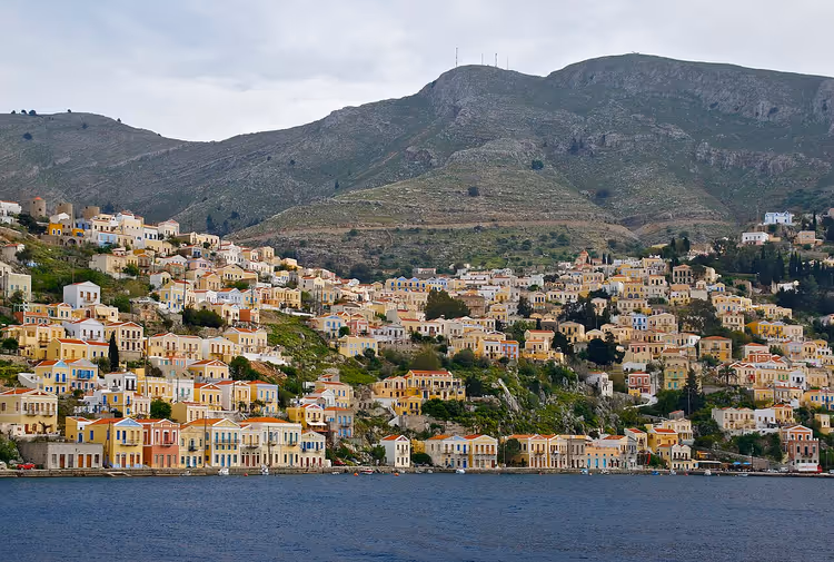 Kleurrijke huizen van Symi op de helling boven de zee