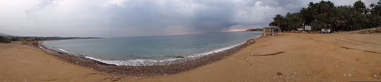 Plage de sable de Coral Bay sous un ciel nuageux