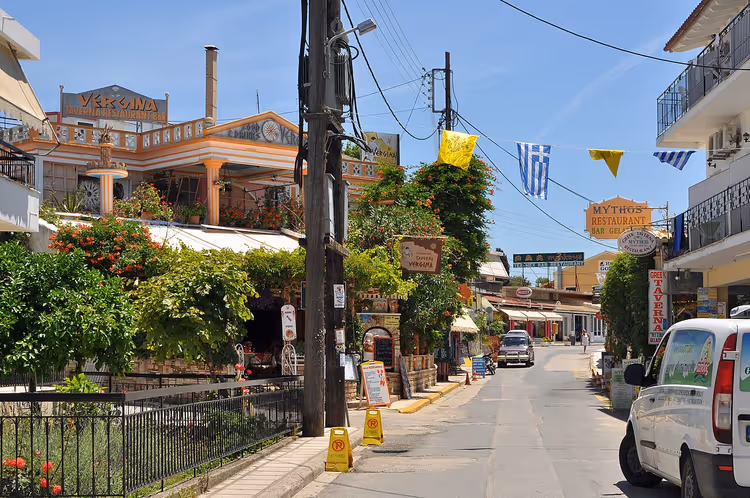 Straat in Gouvia met taverna's en Griekse vlaggen
