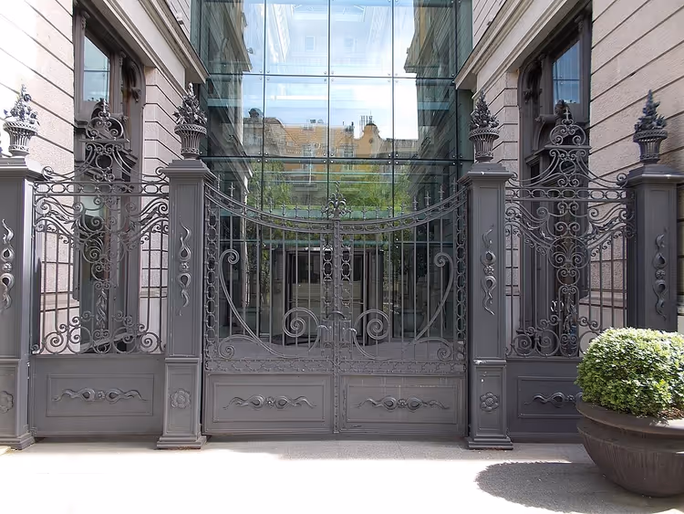 Кованые ворота и стеклянный атриум отеля Corinthia