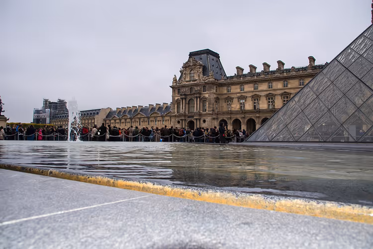 Cour Napoléon des Louvre mit der Glaspyramide und Touristinnen und Touristen