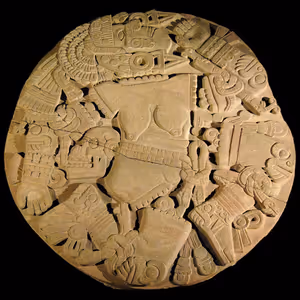 Runder aztekischer Coyolxauhqui-Stein mit Relief einer zerstückelten Göttin, beleuchtet vor schwarzem Hintergrund
