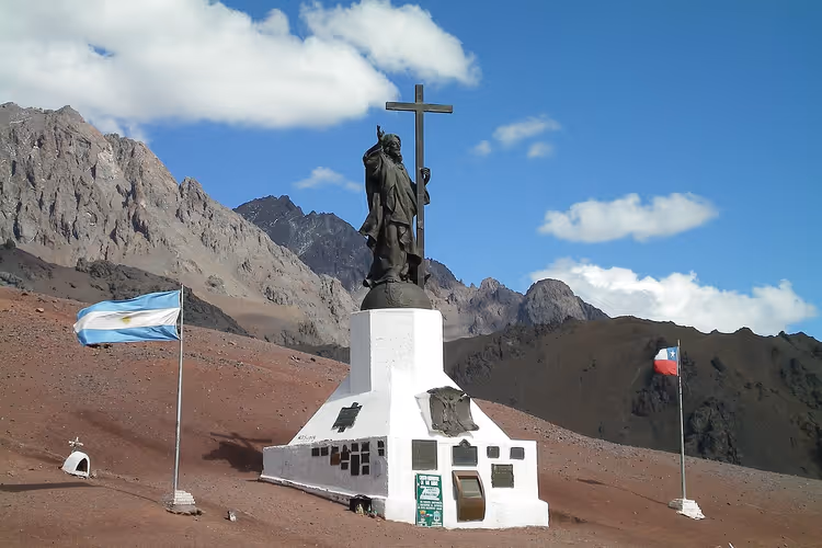 Kristusstatuen i Andesfjellene med et kors i fjellene