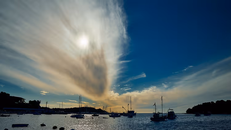 Tekneler ve bir bulutla Rovinj limanı üzerinde gün batımı