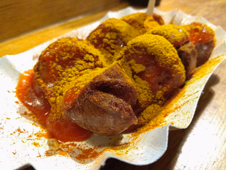 Currywurst med saus og karri på en papptallerken