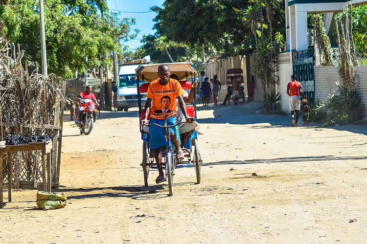 Toliara'da kumlu bir sokakta ilerleyen çekçek
