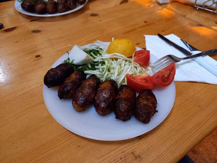 Bord sheftalia met salade, tomaten en citroen