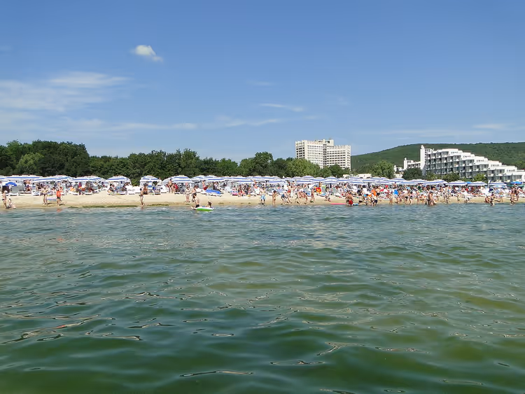 Strand van Albena met parasols en hotels in de verte