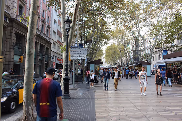 Die Flaniermeile La Rambla in Barcelona mit Platanen und Menschen