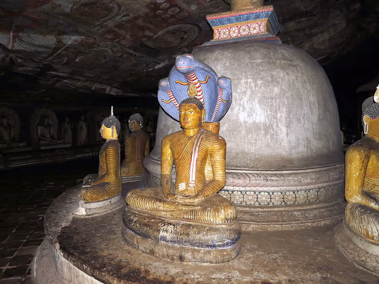 Estatua de Buda con una cobra en el templo rupestre