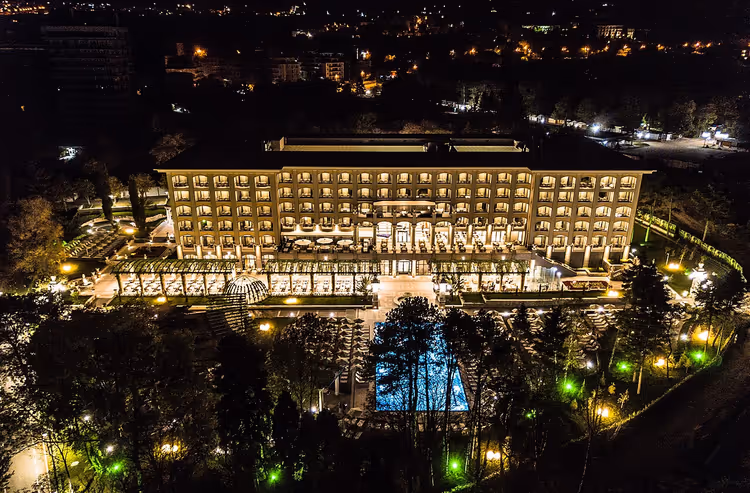 nattutsikt over opplyst hotell med basseng og hage
