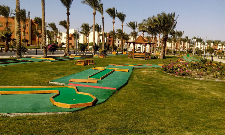 Tatil köyü arazisinde palmiye ağaçları arasında mini golf