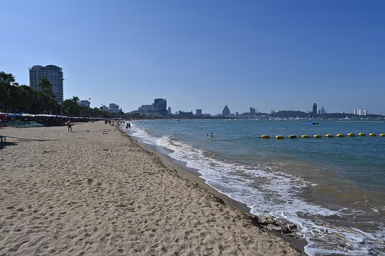Песчаный городской пляж с отелями вдали в ясное утро