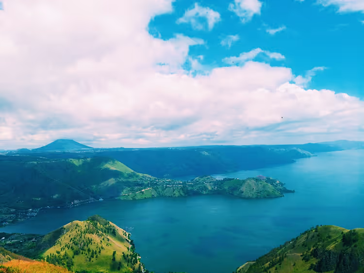Panorama van het Tobameer met groene heuvels en een baai