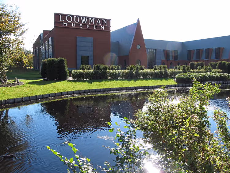 Fasaden til Louwman Museum med skilt ved dammen