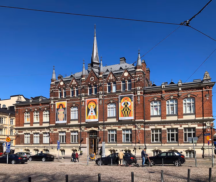 Rød mursteinsbygning for Designmuseum med plakater på fasaden