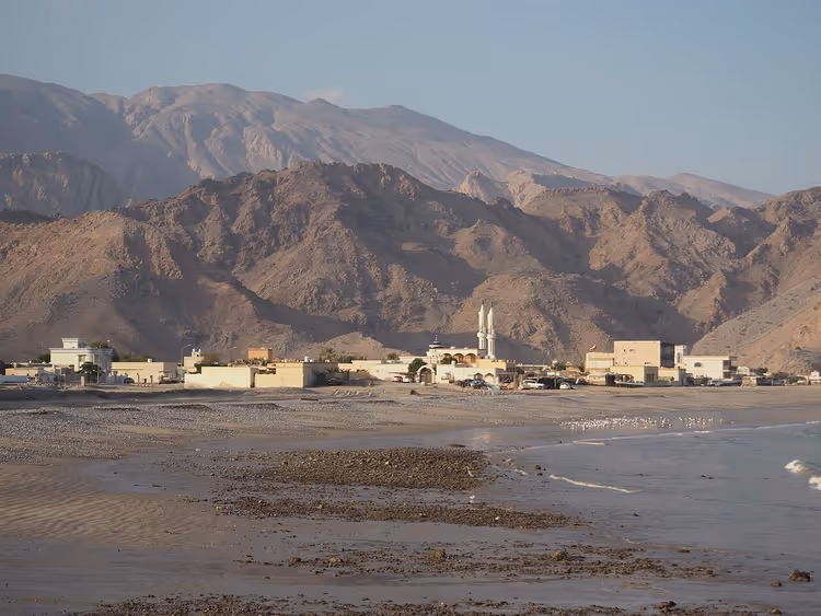 Dibba-stranden med landsby og fjell
