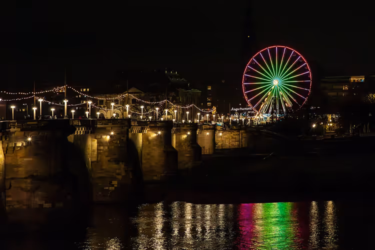 Nächtliche Brücke mit Lichtern und Riesenrad