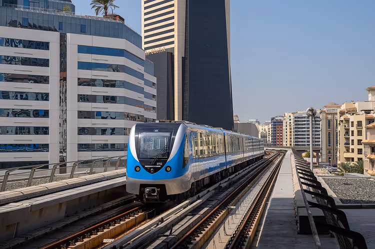 Gökdelenler arasında yükseltilmiş rayda Dubai Metrosu treni