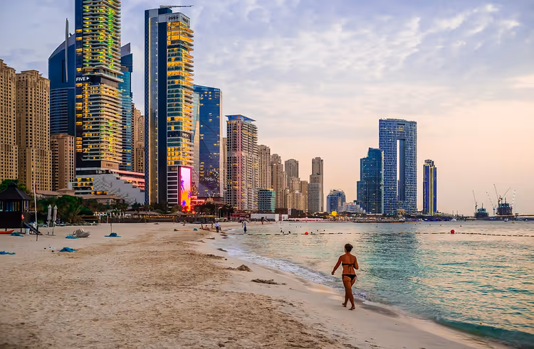 Gün batımında gökdelenlerle Dubai Marina plajı