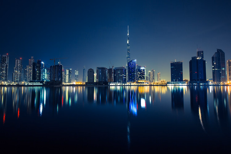 Centro de Dubái de noche con el Burj Khalifa sobre el agua