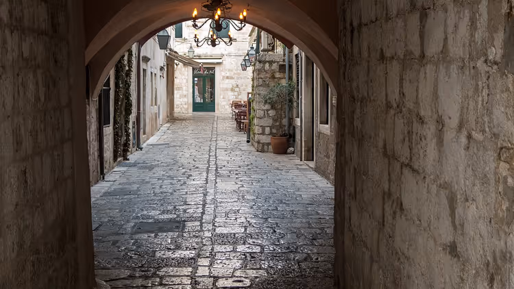 Gammel steingate under en bue i Dubrovnik