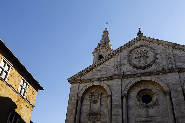 Mavi gökyüzüne karşı Pienza Katedrali cephesi