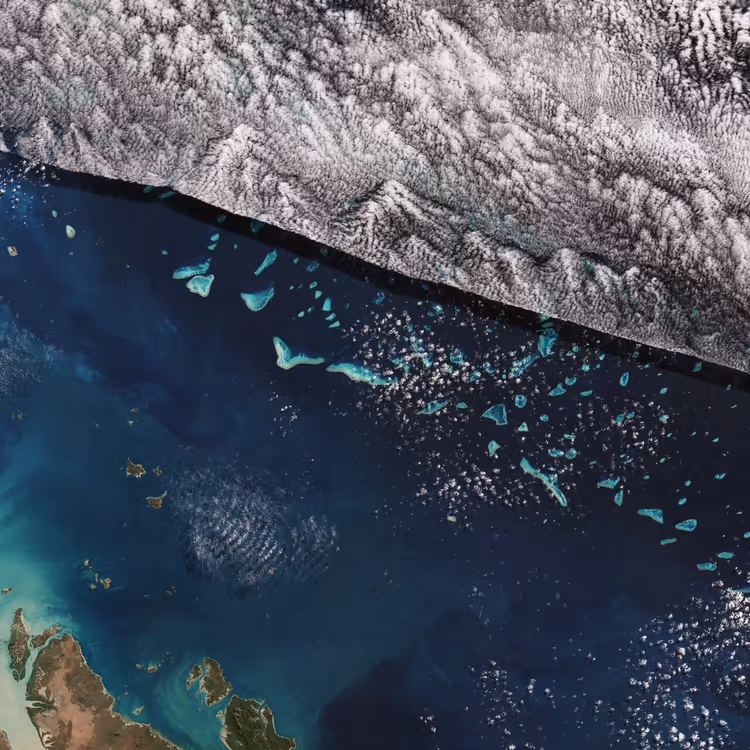 Satellietbeeld van het Great Barrier Reef met wolken en ondiepten