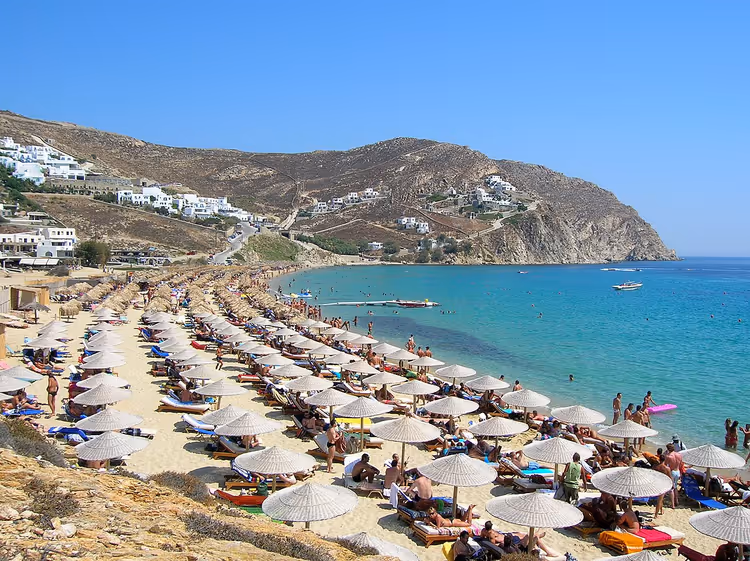 La playa de Elia con sombrillas y villas en las laderas