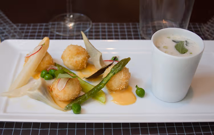 Forrett på restaurant med panerte kuler og asparges