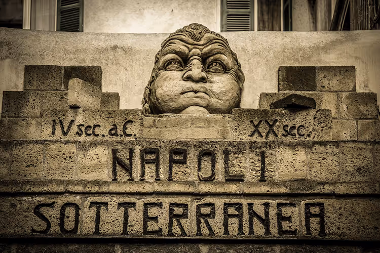 Steinskiltet til Napoli Sotterranea med et skulpturert ansikt