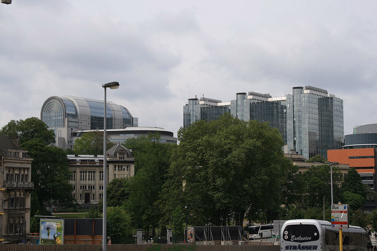 Glazen gebouwen van het Europees Parlement boven de bomen van Brussel