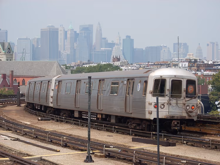 U-Bahn-Zug in New York City mit Manhattan im Hintergrund