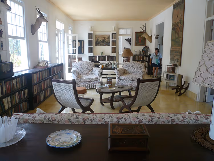 Woonkamer in het huis van Hemingway met fauteuils en boeken