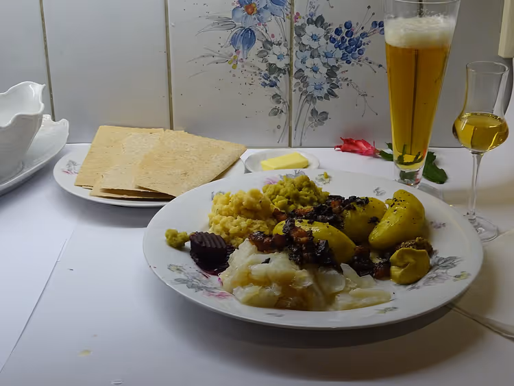 Patates, lefse ve içeceklerle lutefisk tabağı