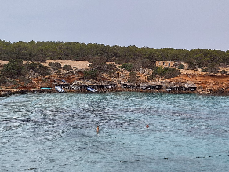Turkise Cala Saona-viken med båtskur