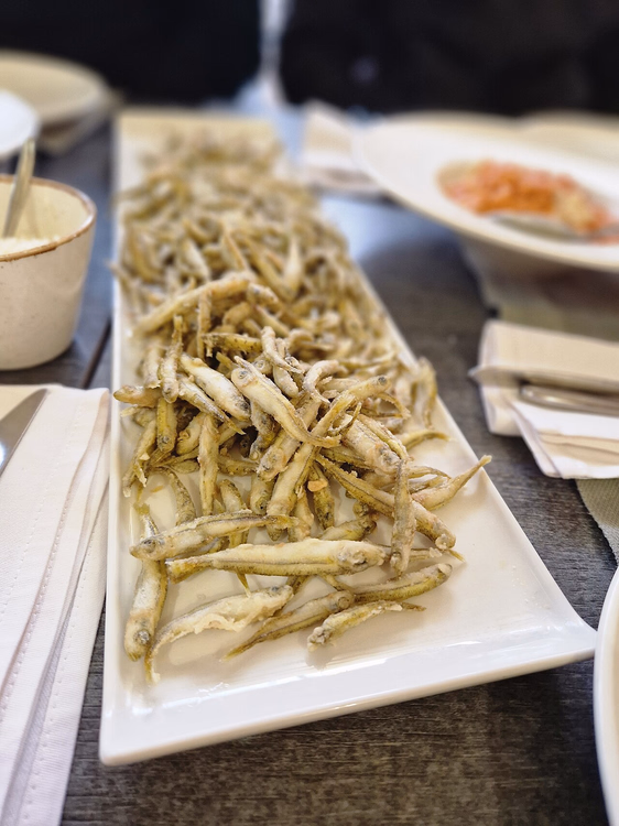 Fried small fish on a long white platter