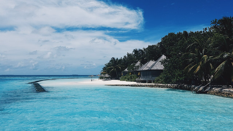 Villa's met rieten dak aan een turquoise lagune