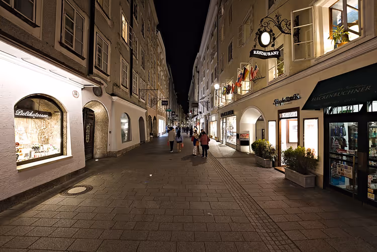 Getreidegasse om natten med butikker og skilt
