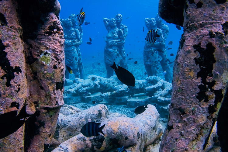 Unterwasserskulpturen von Menschen zwischen Fischen vor Gili