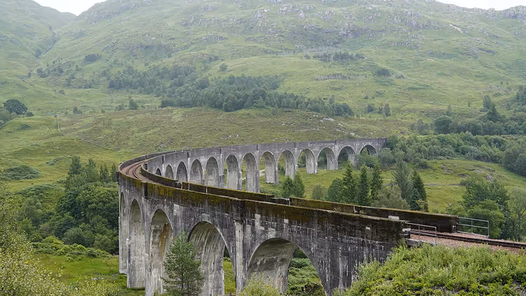 Yeşil İskoç tepeleri arasında kıvrılan Glenfinnan Viyadüğü
