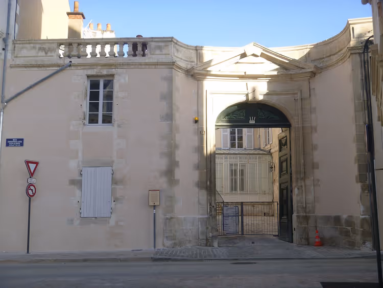 Historisk fasade med bue og port i Poitiers
