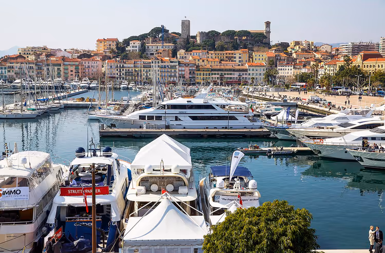 Jachten in de haven van Cannes met de oude stad op de achtergrond