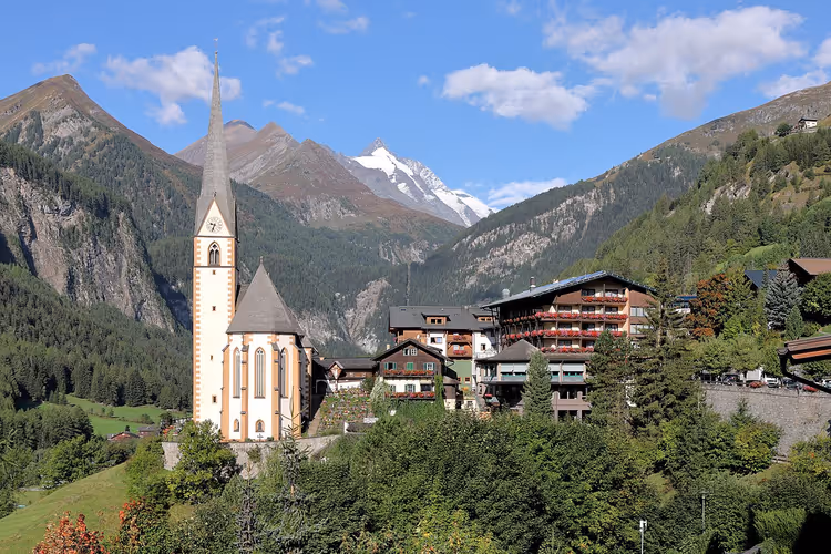Fjelllandsby med kirke og snødekte topper