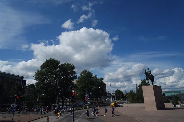 Stadsplein, bomen, mensen en ruiterstandbeeld aan de rechterkant