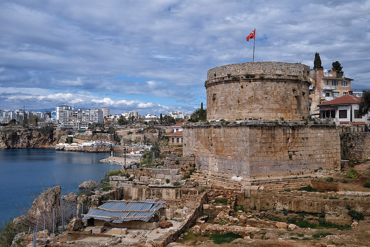 Hıdırlık-tårnet med et flagg over bukten i Antalya