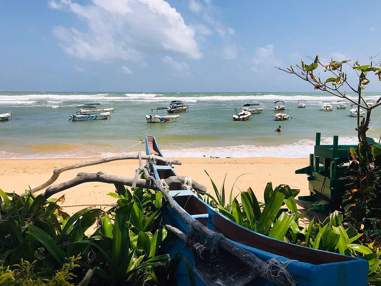 Barcos en la bahía frente a la playa de arena de Hikkaduwa